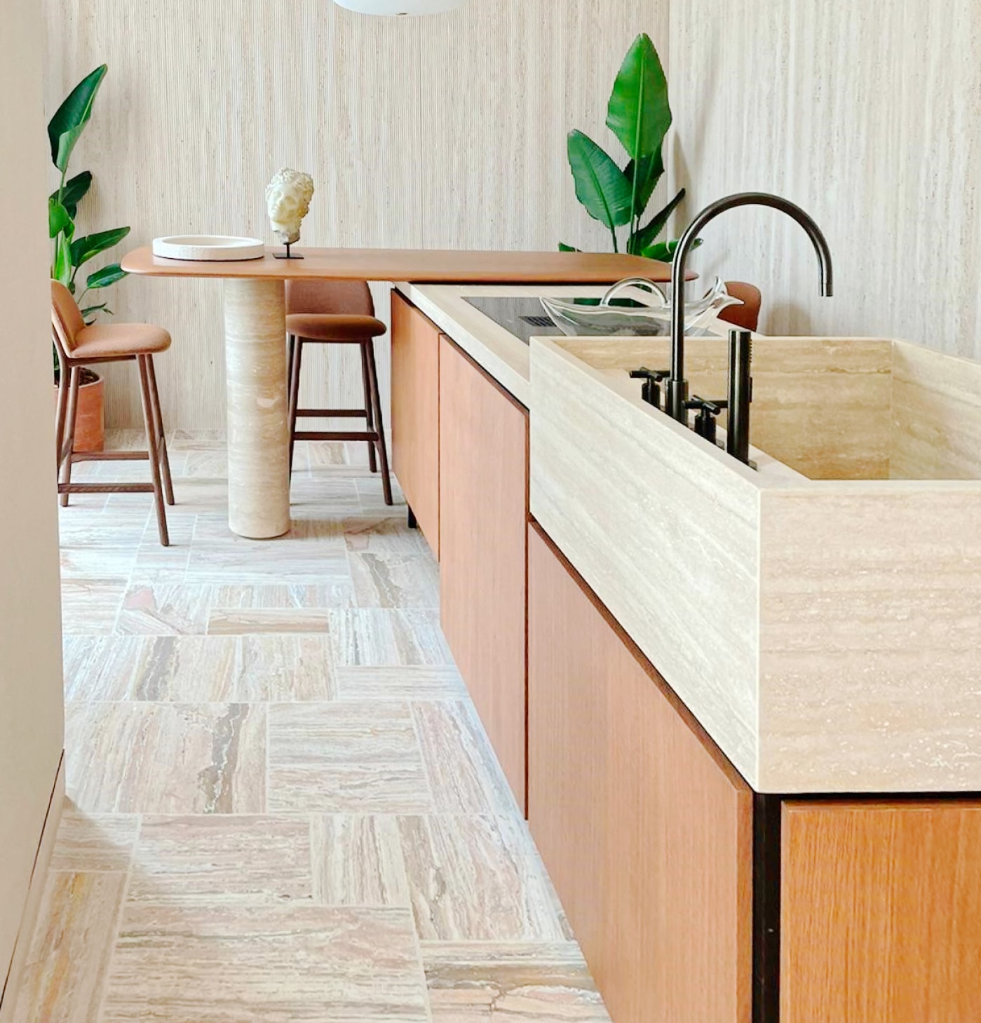 Cucina con piano in travertino, rubinetto nero e sgabelli